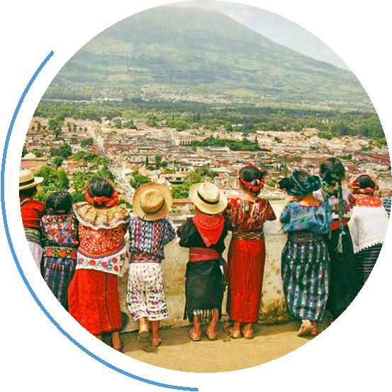 Bunt gekleidete Kinder schauen von einem Balkon auf Guatemala Stadt