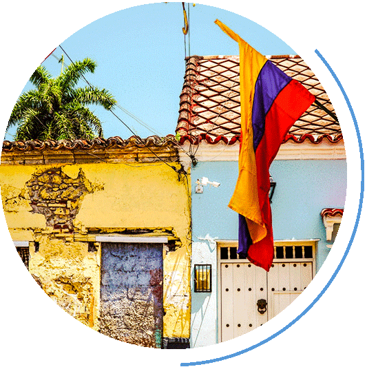 Kolumbiens Fahne vor zwei bunten Häusern