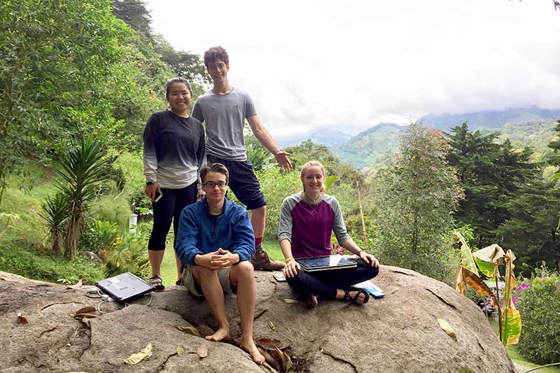 Freiwillige sitzen auf Steinen im Dschungel in Costa Rica