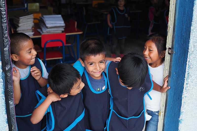 Kinder lächeln in die Kamer im Teaching Projekt in Guatemala