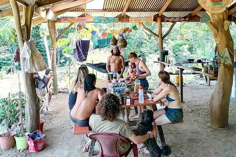Freiwillige sitzen zusammen und essen in der Permaculture in Costa Rica
