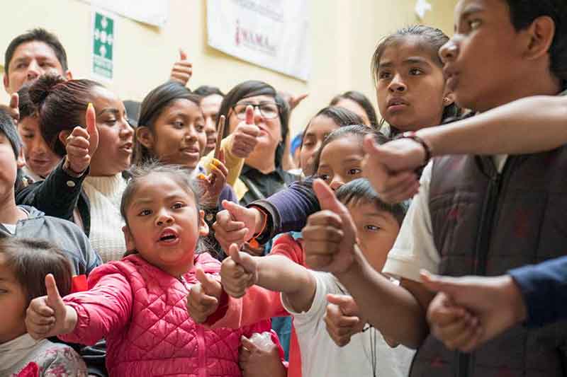 Children show thumbs up in school in Mexico