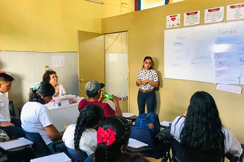 Lehrerin erklärt etwas an der Tafel in Schule in Mexiko