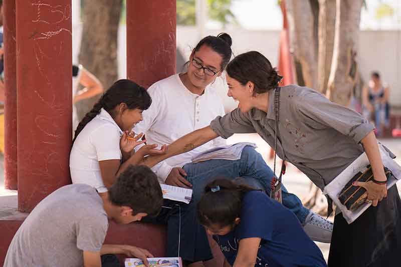 Teachers laugh with children in school in Mexico