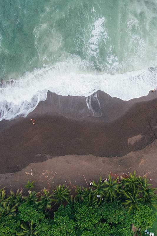 Menschen laufen an Sandstrand aus Drohnen Perspektive in Costa Rica