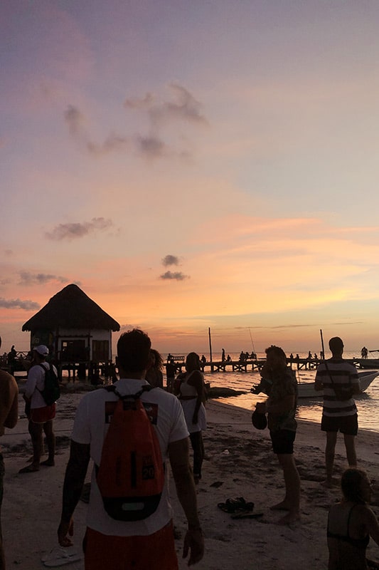 Menschen am Strand bei Sonnenuntergang