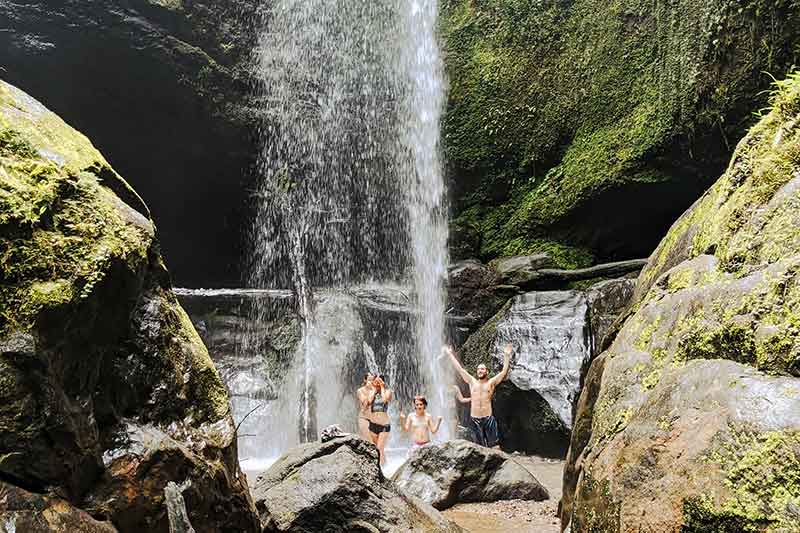 Freiwillige duschen unter Wasserfall in der Permaculture in Costa Rica