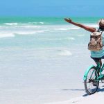 Mann fährt Fahrrad am Strand
