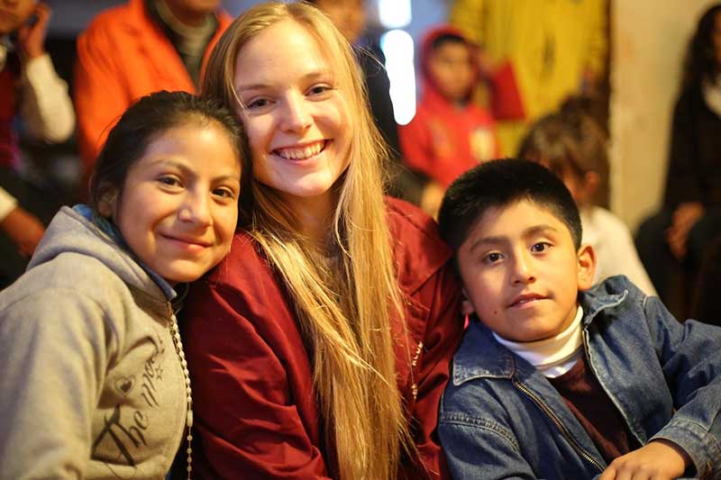 Freiwillige lacht mit peruanischen Kindern