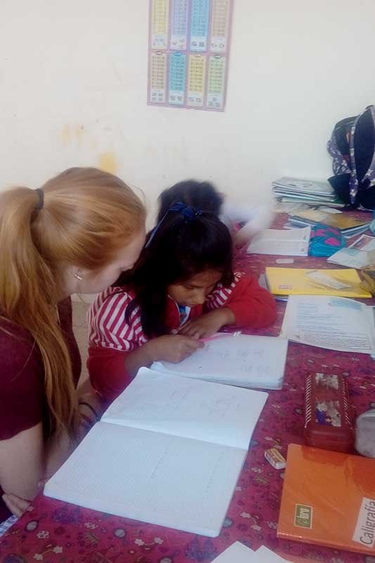 Freiwillige lernt mit peruanischem Kind