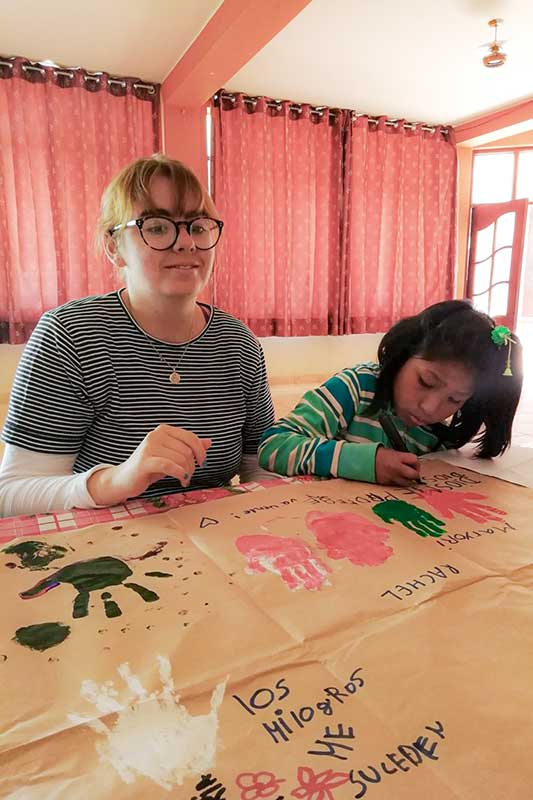 Volunteer paints with Peruvian child