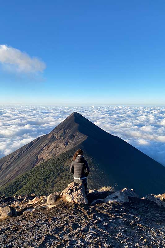 Asude sitzt vor dem Vulkan Fuego in Guatemala