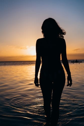 Silhouette eine Frau vor Sonnenuntergang am Meer