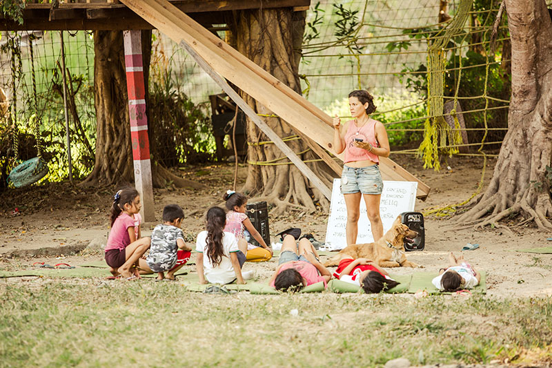 Volunteer explains to children outdoors in Childcare project in Mexico