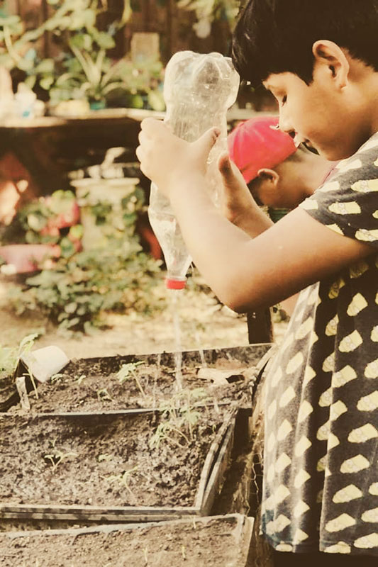Kinder helfen Pflanzen gießen im Childcare Projekt in Mexiko