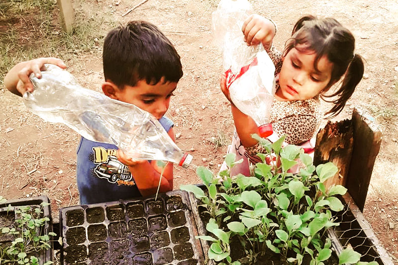 Children help water plants in Childcare project in Mexico