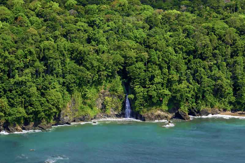 verlassener Strand mit Wasserfall und Dschungel in Costa Rica