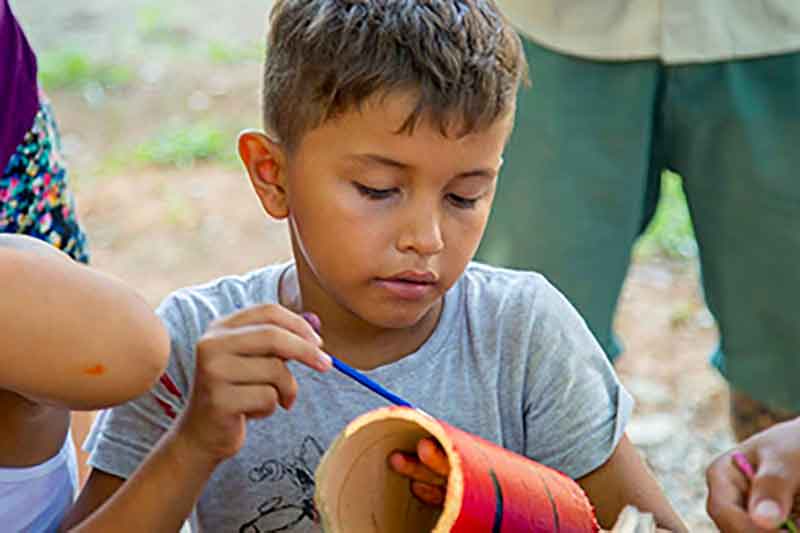 Einheimischer Junge bemalt Bambus in Costa Rica