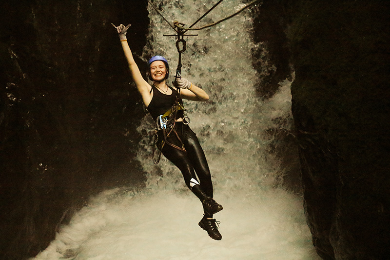 Isabelle beim Ziplining vor einem Wasserfall