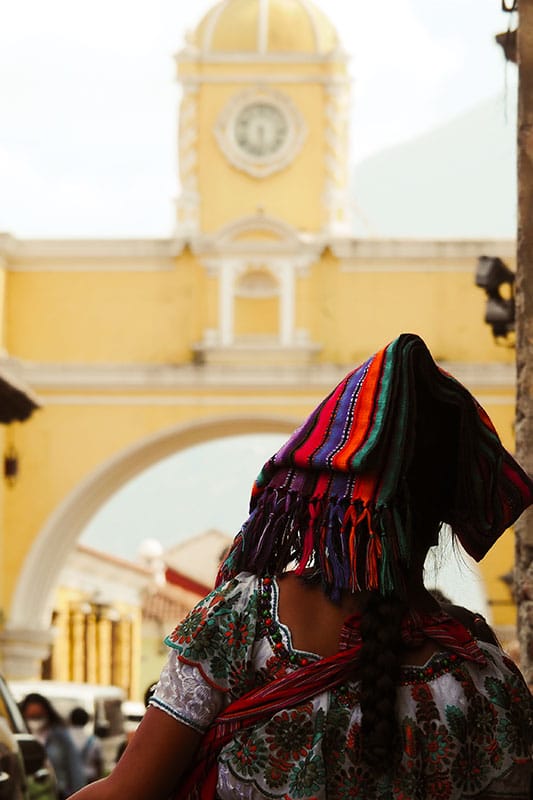 Frau vor gelbem Turm in Antigua Guatemala