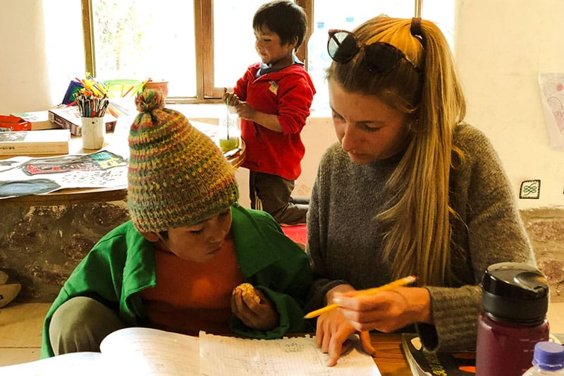 Jenny hilft einem Kind beim Lernen