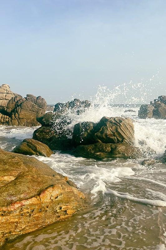 Wellen schlagen auf Steine am Strand