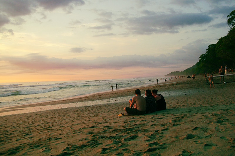 gruppe von menschen am Strand mit sonnenuntergang