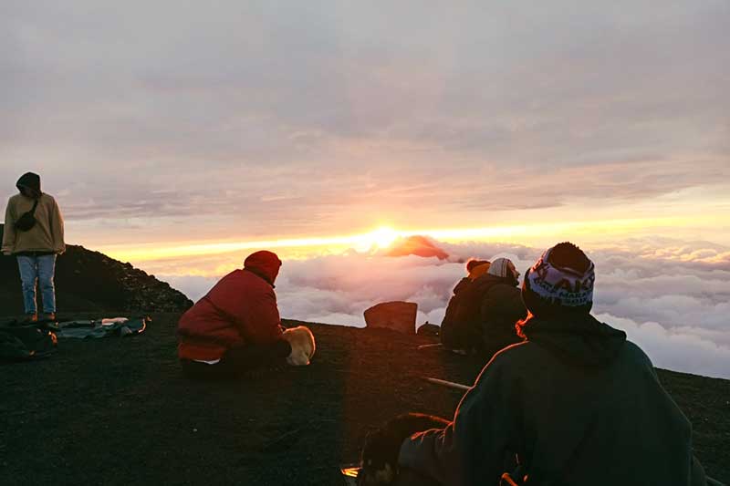 Gruppe sitzt zusammen auf dem Vulkan
