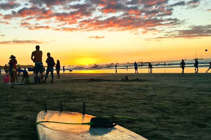 Surfbrett liegt am Strand bei Sonnenuntergang
