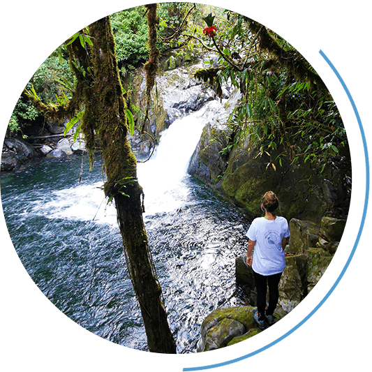 Unsere Teilnehmerin steht am Wasserfall im Regenwaldreservat