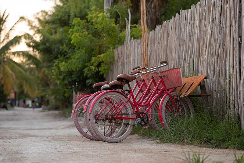 rote Fahrräder stehen an Zaun in Mexiko
