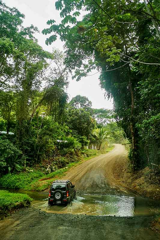 Jeep fährt durch Pfütze im Dschungel in Costa Rica