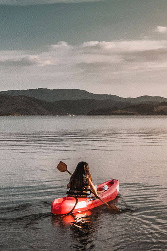 Frau fährt Kayak auf einer Lagune