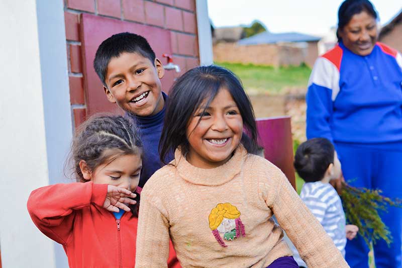 Peruvian children laughing into the camera in Cusco