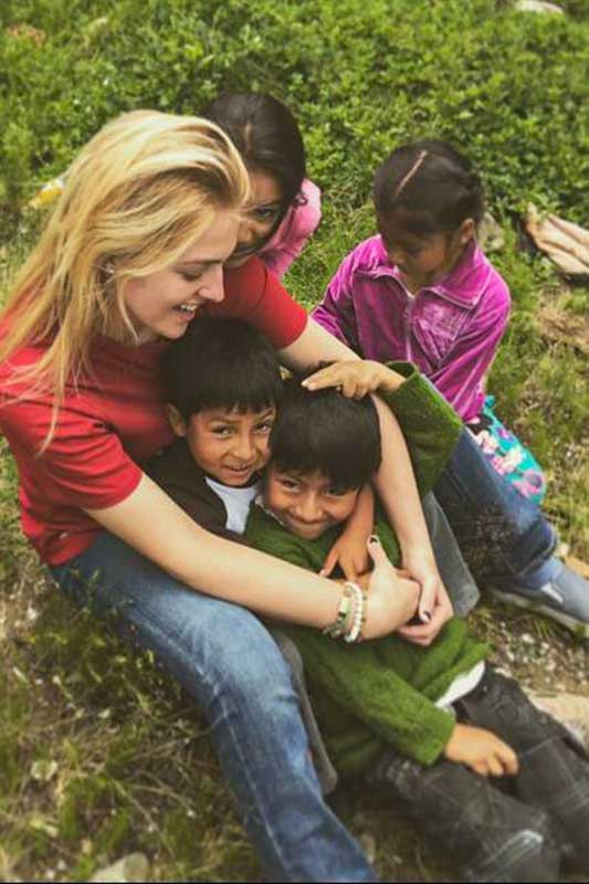 Volunteer laughs with Peruvian children