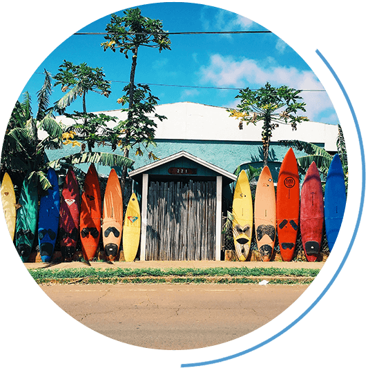 Bunte Surfboards lehnen an einem Holzzaun