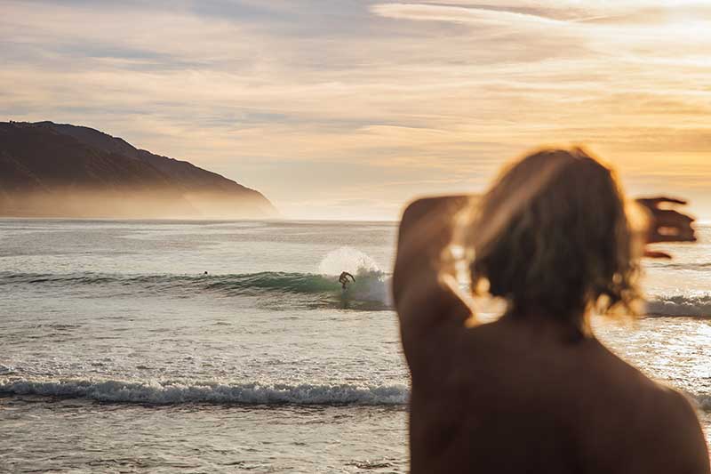 Mann schaut auf Surfer im Meer in Costa Rica