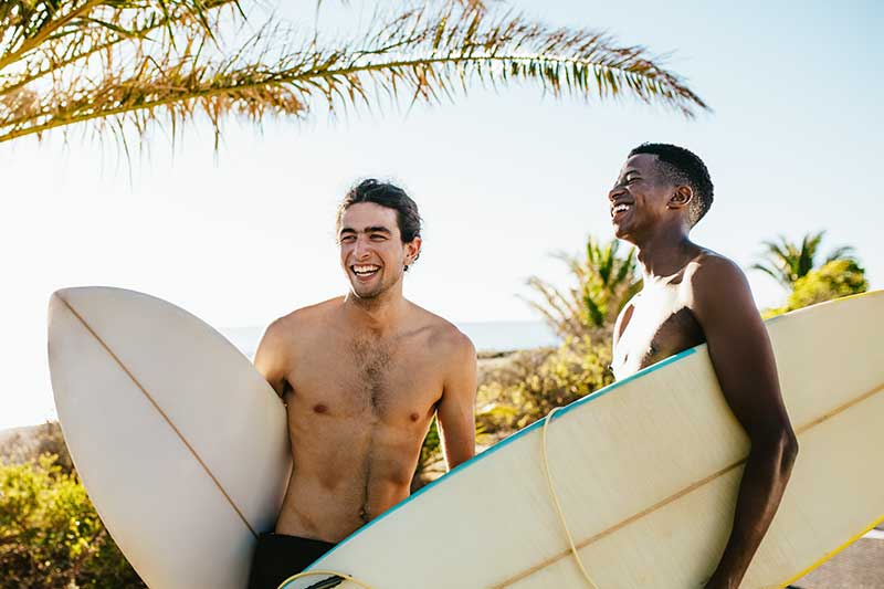 Surfer haben Surfbrett unter dem Arm und lachen in Costa Rica