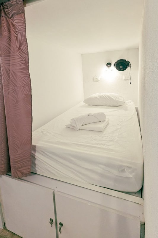 Einzelbett im Mehrbettzimmer mit Lampe und Schliessfach