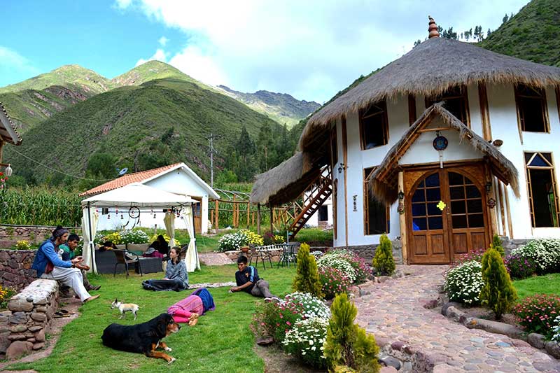 House with garden and Peruvian in front of mountain in Cusco