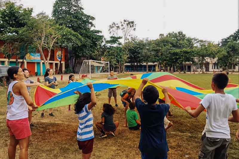 Kinder spielen mit buntem Tuch in Costa Rica