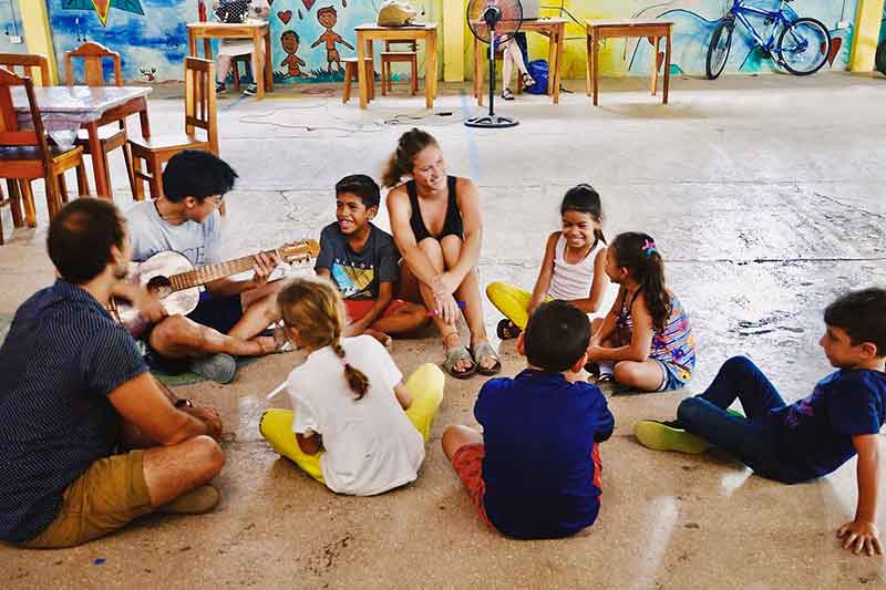 Freiwillige und Kinder spielen Gitarre und singen in Costa Rica