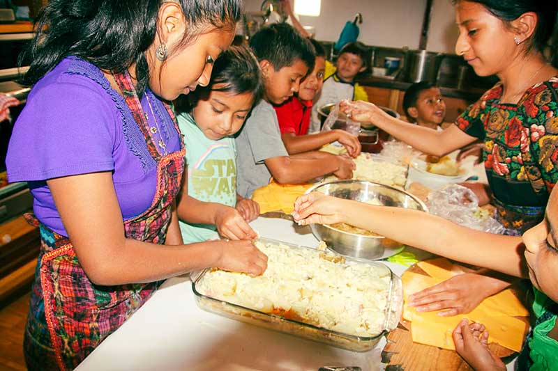 Einheimische Kinder helfen beim Kochen im Youth Development Projekt in Antigua in Guatemala