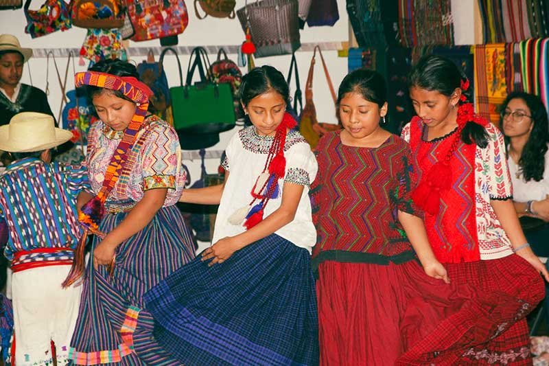 Einheimische Kinder tanzen in traditionellen Klamotten in Antigua Guatemala